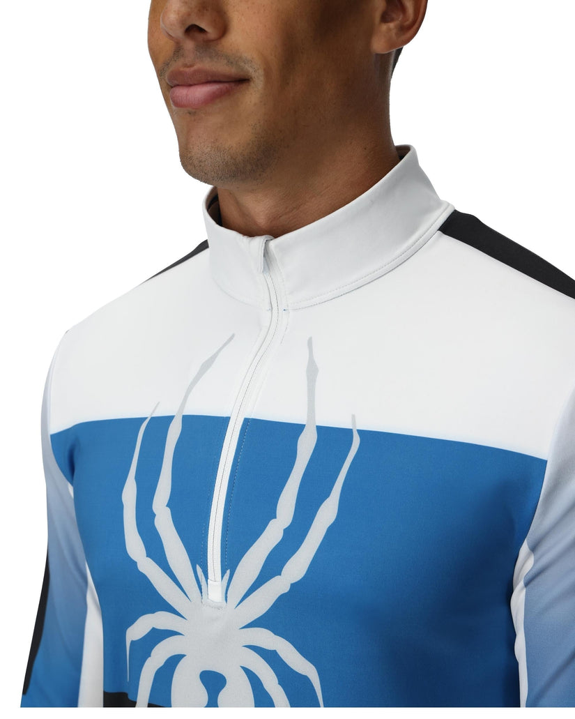 Person wearing a white and blue cycling jersey with a spider logo.