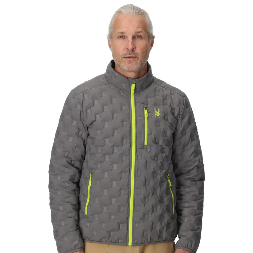 Man wearing a gray quilted jacket with yellow zippers on a white background