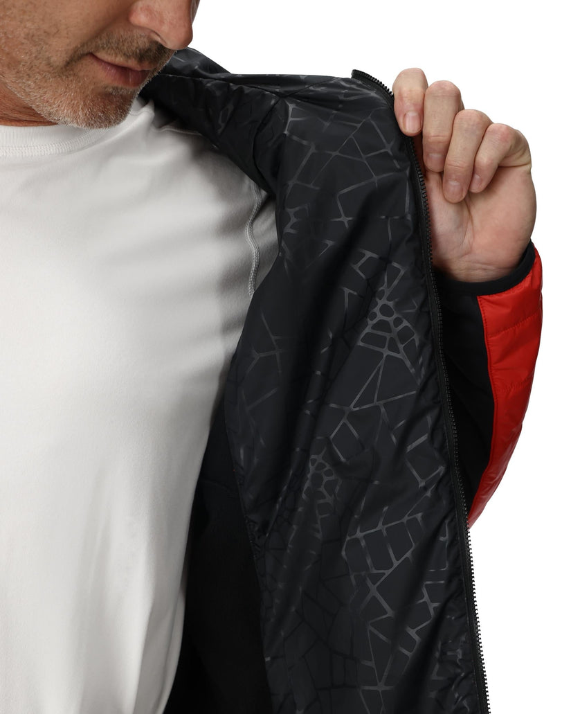 Person wearing a black jacket with geometric patterns and red sleeves, holding the jacket open.