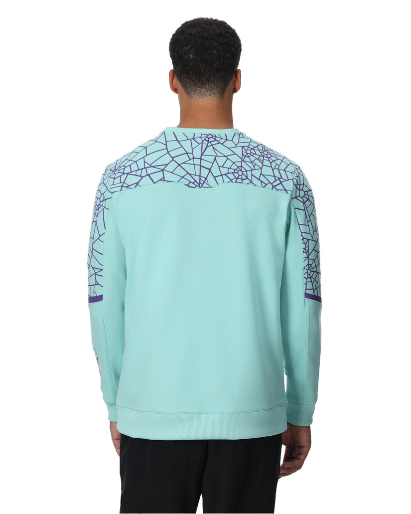 Person wearing a light blue sweatshirt with geometric pattern on a white background