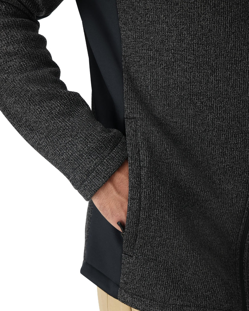 Close-up of a person wearing a dark gray textured coat with a white background
