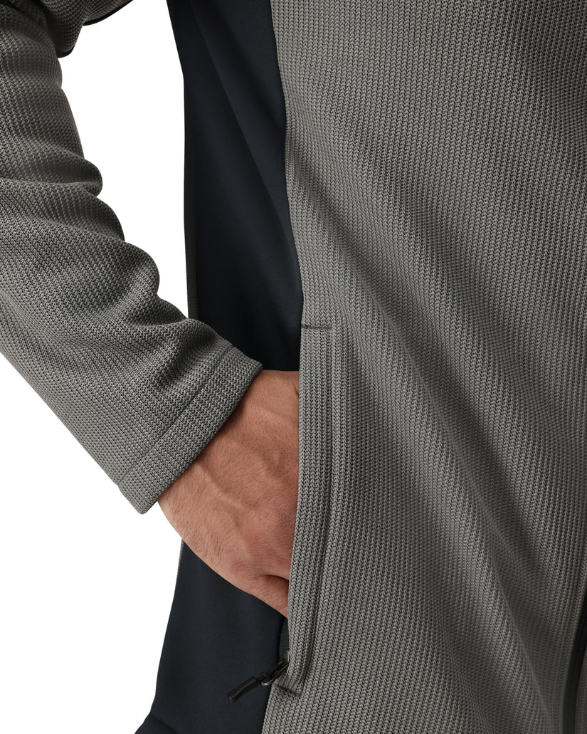 Close-up of a person wearing a gray textured jacket with a white background