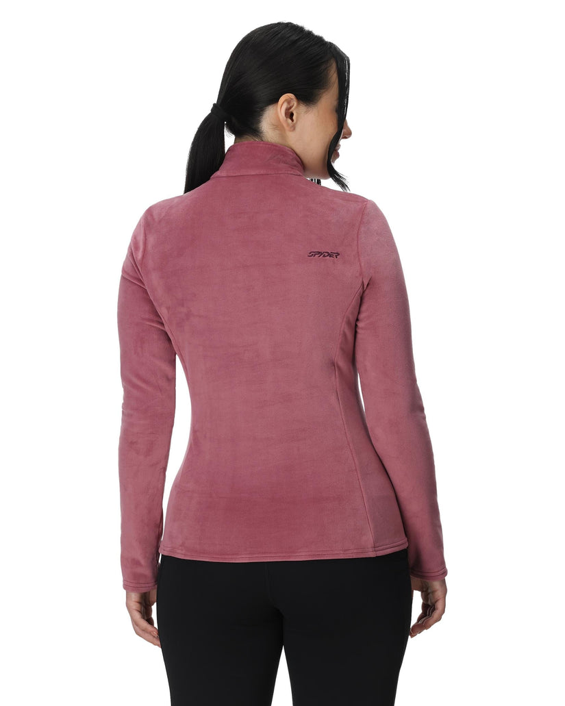 Woman wearing a pink fleece jacket with a brand logo on a white background