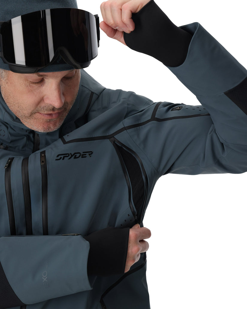 Person wearing a Spyder jacket and goggles on a white background