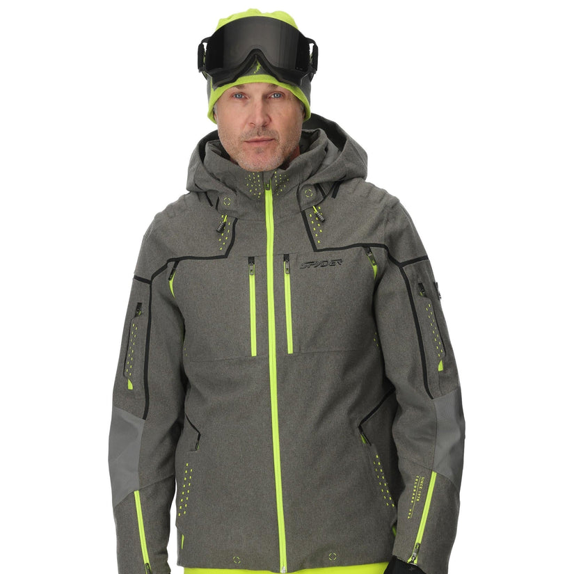 Person wearing a gray and green ski jacket with matching pants on a white background