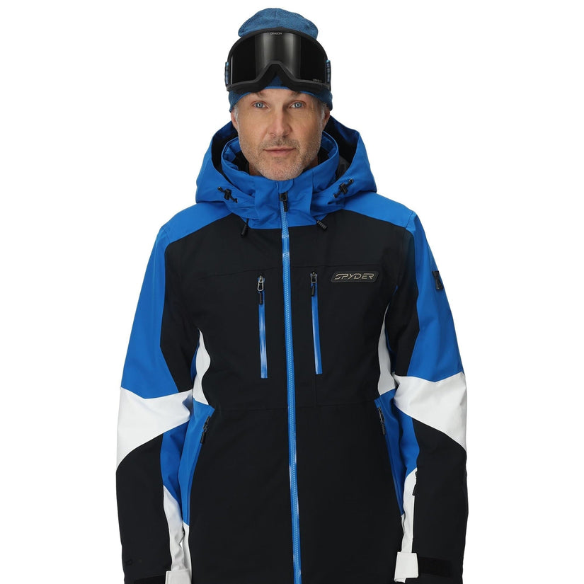 Person wearing a black and blue ski jacket with white accents on a white background