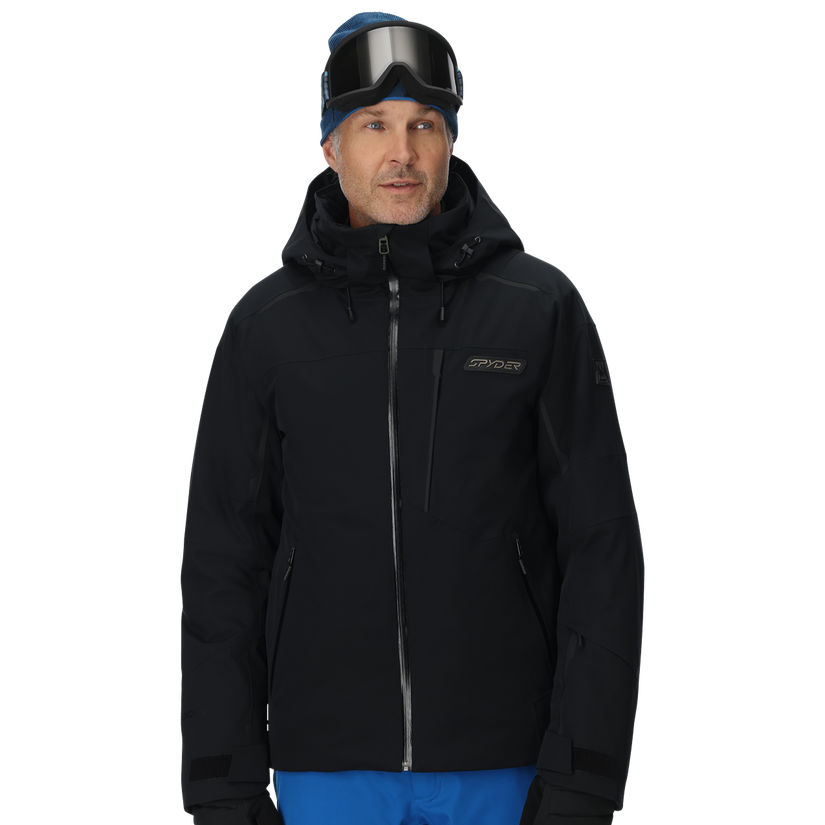Man wearing a black ski jacket and blue pants on a white background