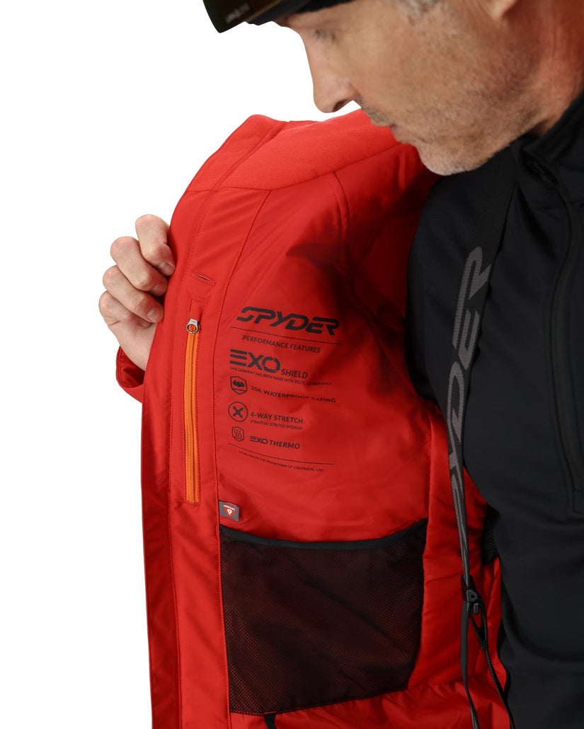 Person wearing a red jacket with 'Spyder' branding on a white background