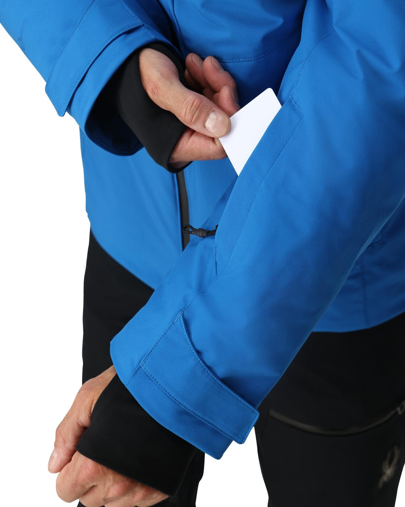 Person wearing a blue jacket with black cuffs on a white background