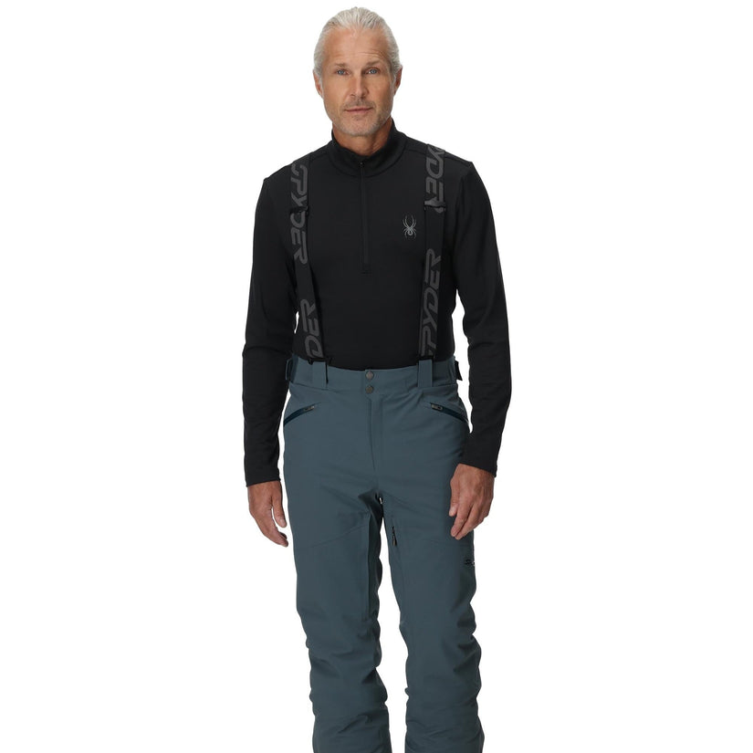 Man wearing a black long-sleeve shirt and blue pants with a white background