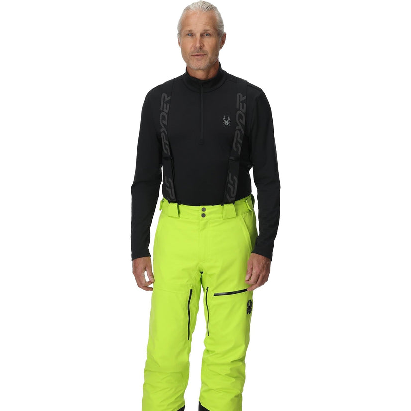 Person wearing a black top and bright green pants on a white background