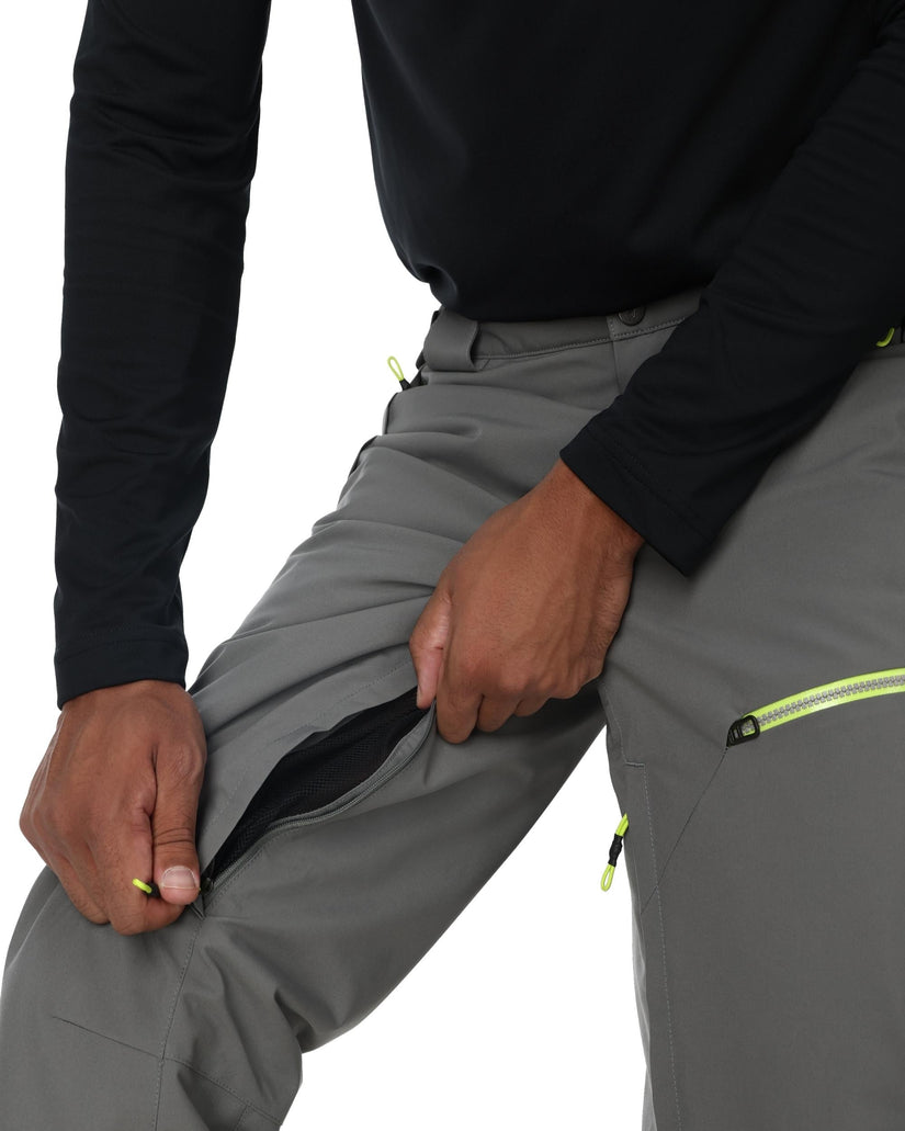 Person wearing gray pants with a focus on the zipper area against a white background