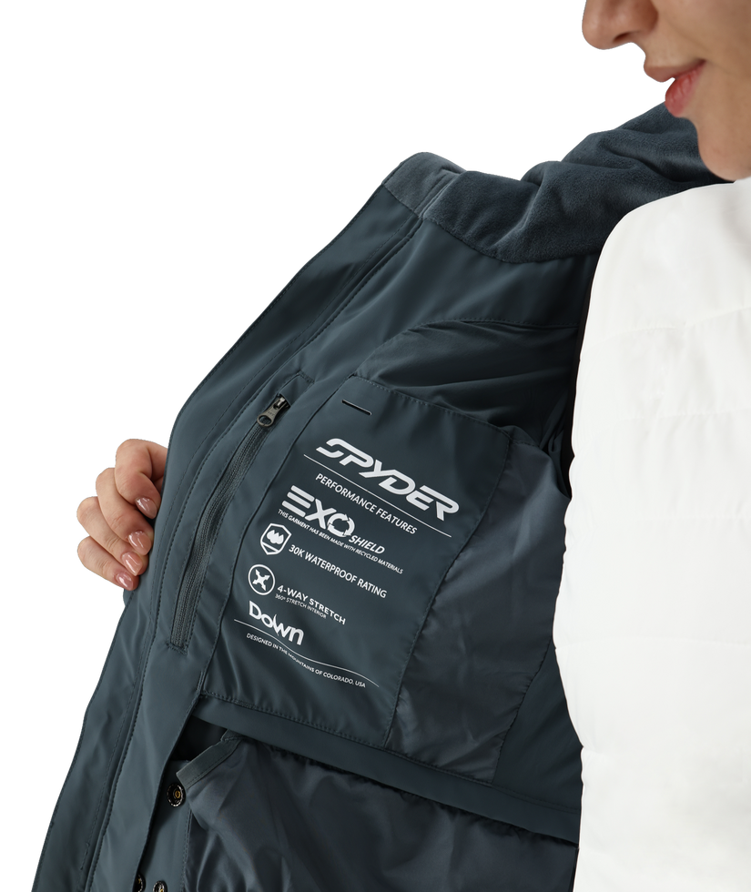 Person wearing a dark jacket with Spyder branding on a white background