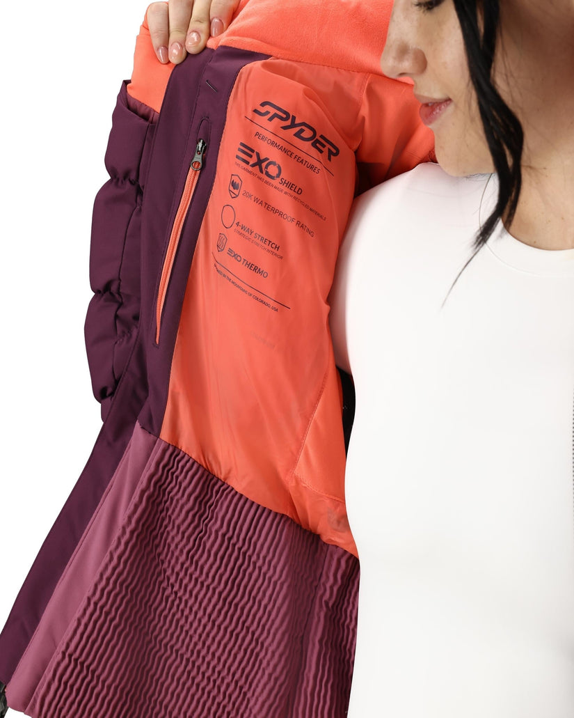 Person wearing a Spyder jacket with a focus on the brand logo.