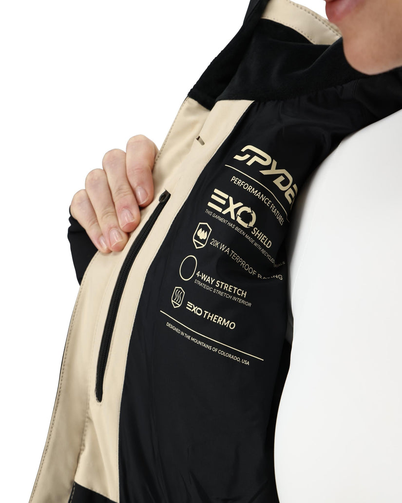 Close-up of a jacket with Spyde branding and feature text on a white background