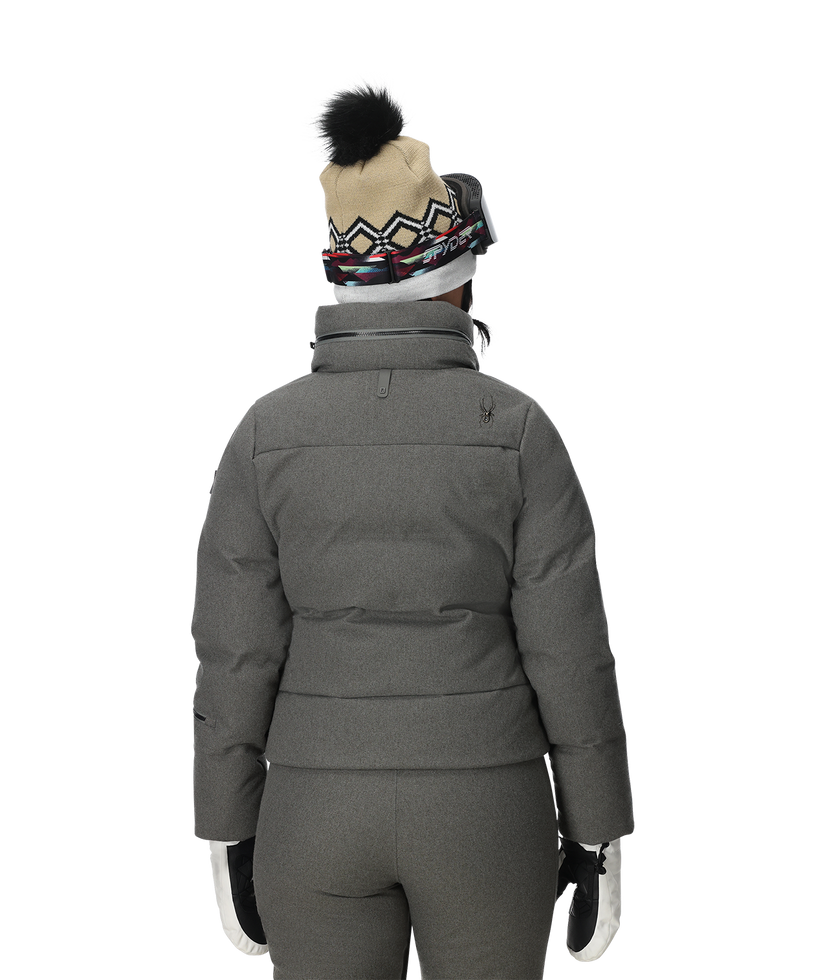 Person wearing a gray winter coat, pants, and hat on a white background